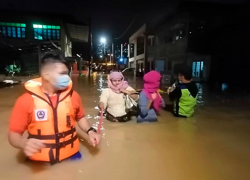 民防部队、警方及志愿警卫成员周日漏夜将新山陈厝港的灾民迁移到武吉珍珠国小疏散中心。（马新社图）