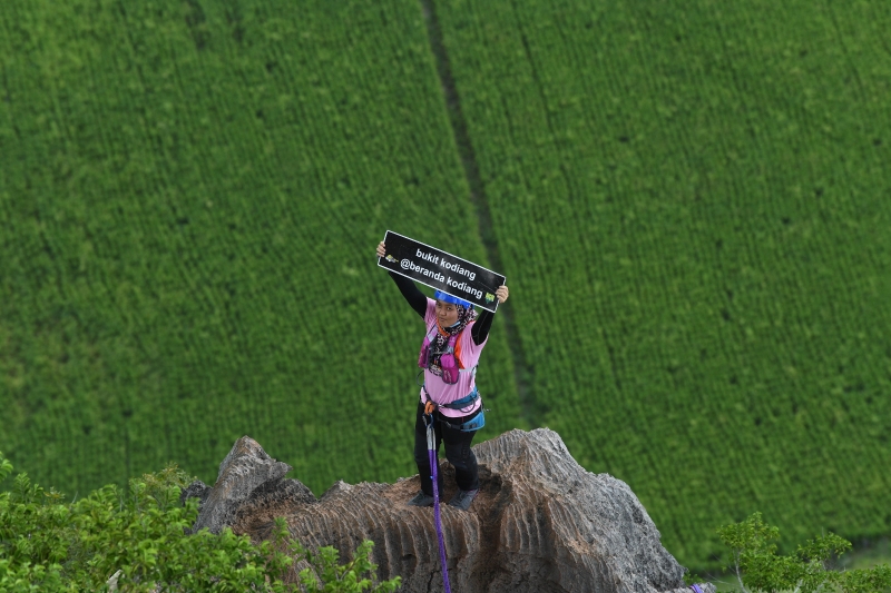 参与者成功登顶后高举“高岭山（kodiang）”纸条。