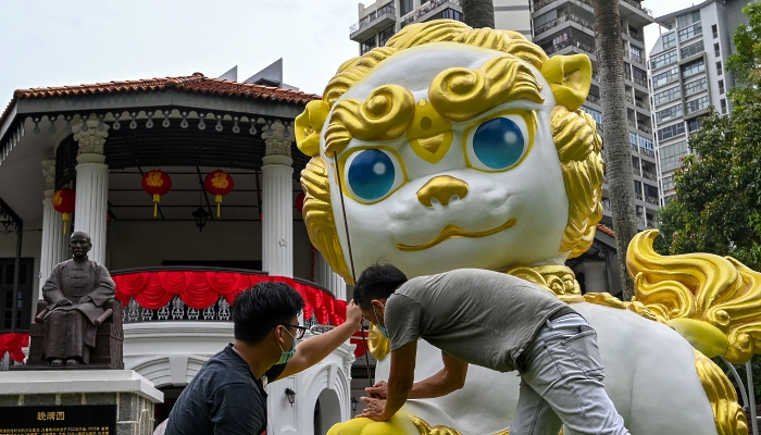 Workers give the finishing touch to a guardian lion statue in front of Sun Yat Sen Nanyang Memorial Hall in Singapore ahead of the Lunar New Year. AFP