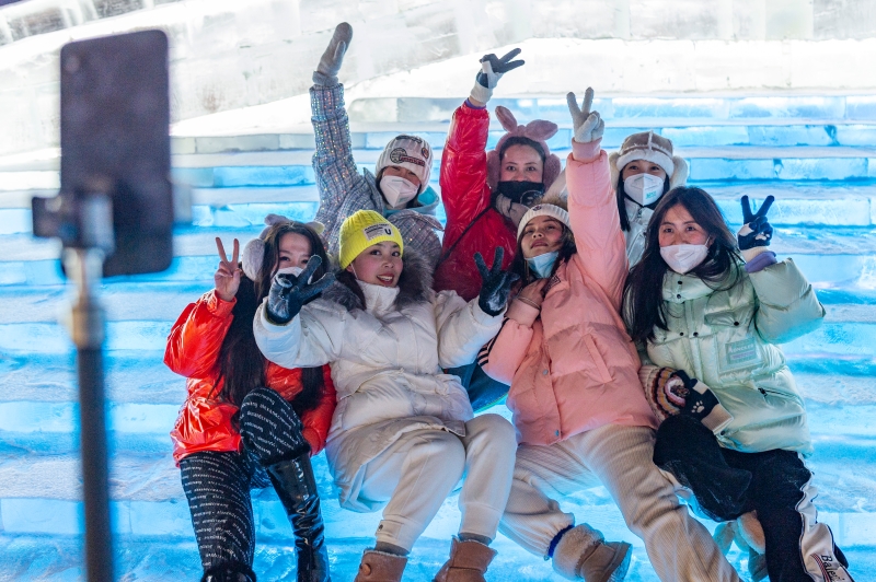 游客在哈尔滨冰雪大世界园区开心自拍。（图：新华社）