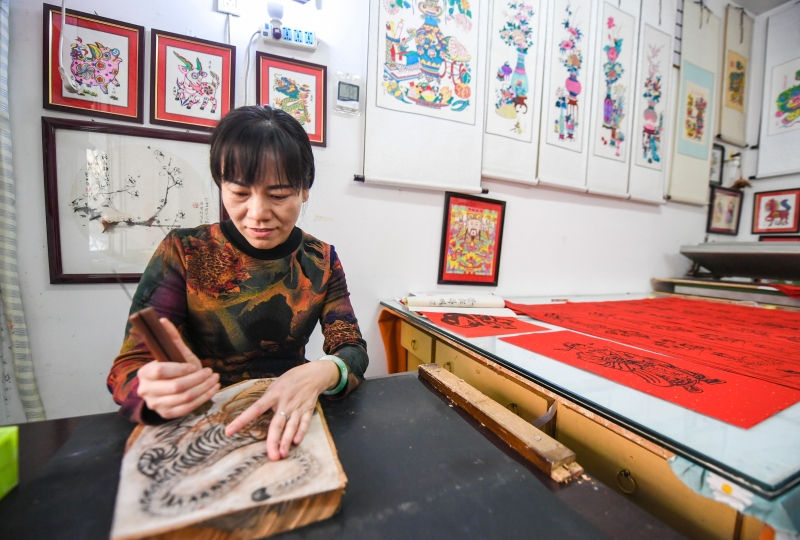 河北省武强县的木版年画传承人辛艳君在雕刻武强年画木版。