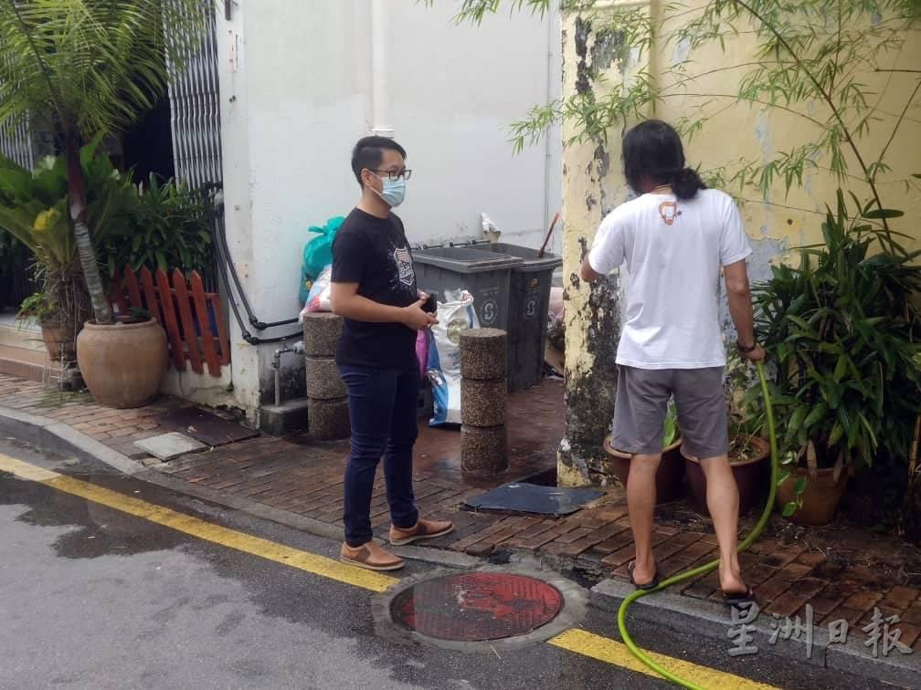 陈炜建（左）向当地商家了解打金街后巷垃圾问题。