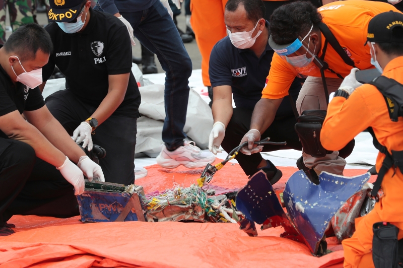 调查员人在雅加达丹戎普鲁克港口检查打捞起物件。（美联社照片）