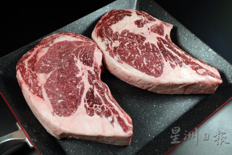 西冷牛排呈长条形，肉的边缘带有一圈油脂且油花遍布。