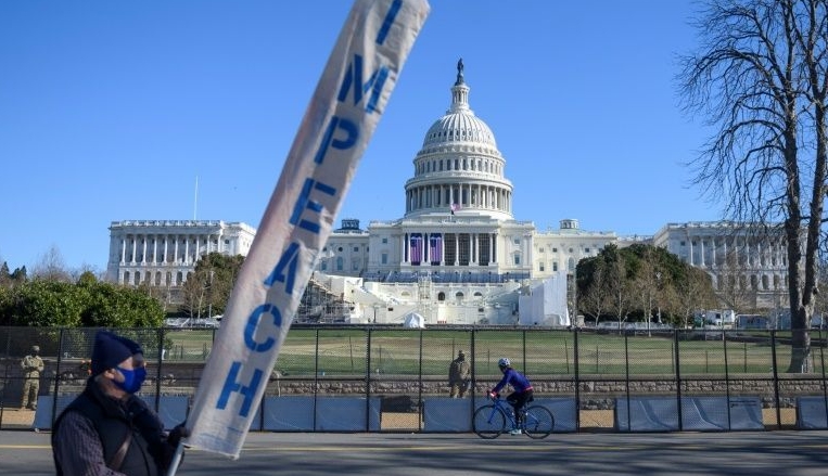 A protester carries a sign calling for Congress to impeach President Donald Trump near the US Capitol. A protester carries a sign calling for Congress to impeach President Donald Trump near the US Capitol.