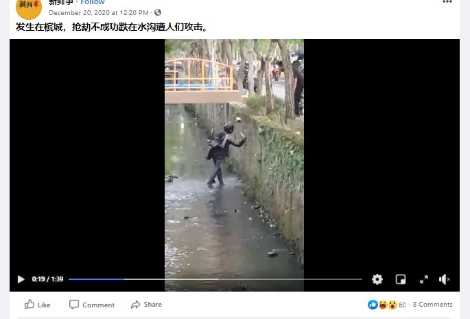 网传槟城发生抢劫不果的匪徒，掉入水沟被人攻击的视频，实际上案发地点在印尼。（截取脸书）