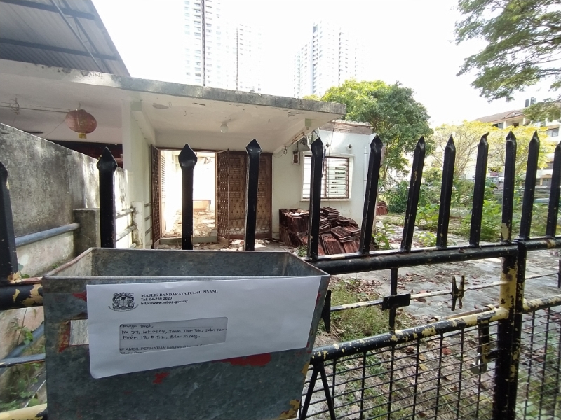 槟岛市政厅要求地主暂时停止拆屋的谕令张贴在屋前。