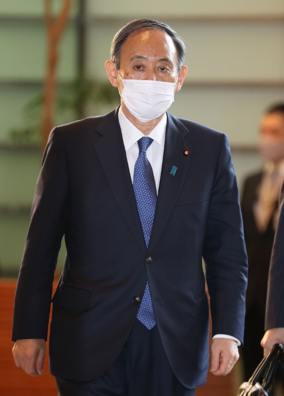 日本首相菅义伟坚称举办东京奥运会和防疫政策慢一拍拉低了自己的民心，他的支持率比起上个月也略有下滑。（法新社照片）