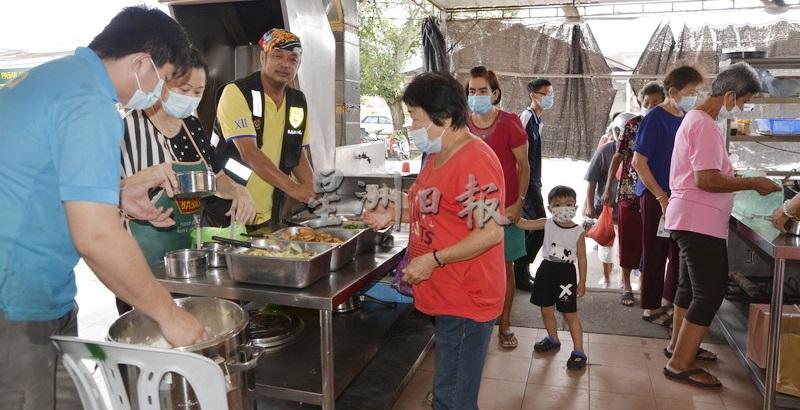 和丰慈济基金会，在竹芭新村派发素食饭餐给贫苦人士。左三是邱振洲。