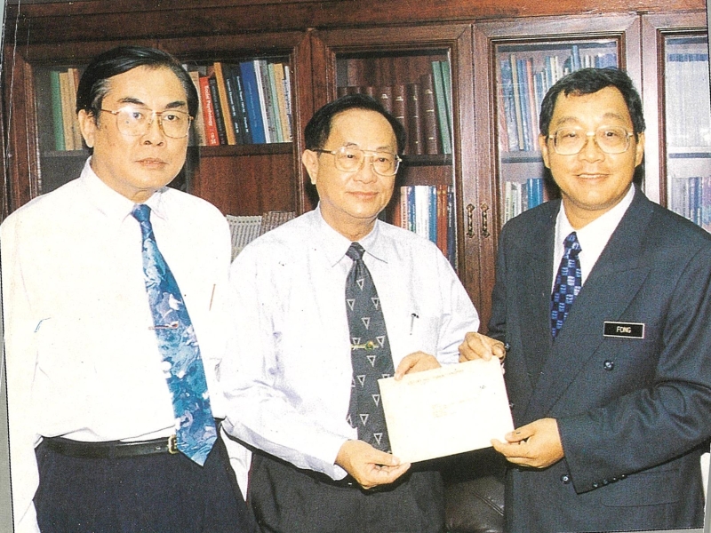 1997年6月11日，时任教育部副部长拿督冯镇安（右）移交设立新纪元学院正式批准信予王超群（左）及时任董总主席郭全强。