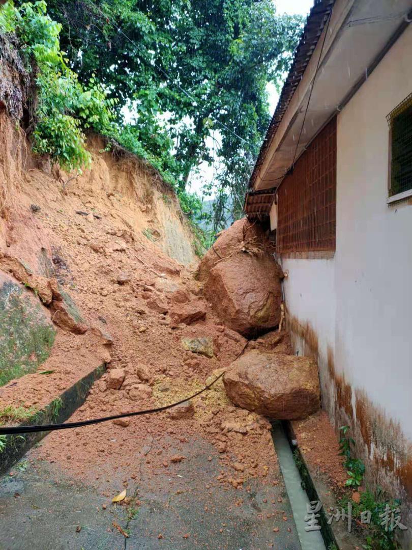 山坡滚下的巨石压到民宅后墙，所幸冲击力不大，否则后果可能更严重。