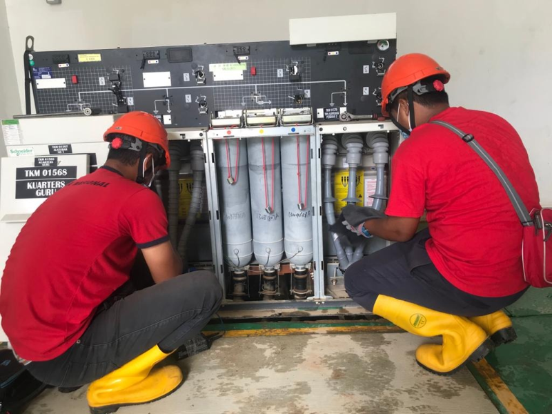 国能职员在甘马挽武吉猛垛（Bukit Mentok)確保电流可安全供应后，方接回电源。