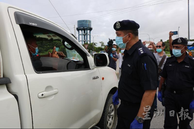 诗巫警区主任史丹里（中）巡视巴拉当路障时查问一名司机。右为南兰警局局长德布拉斯。