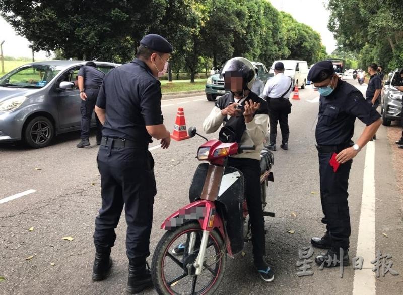 警方向摩托车骑士了解准备前往的目的地。

