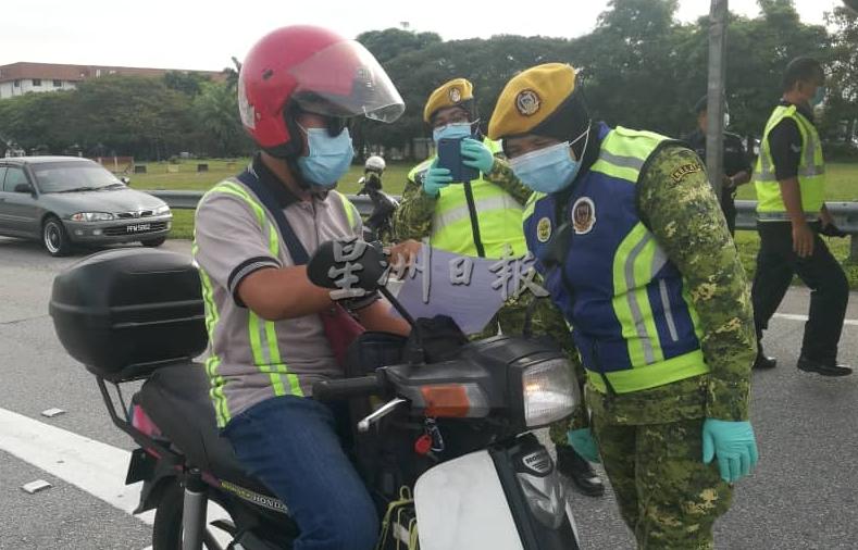 警方严查摩托车骑士出示的工作证明信函。