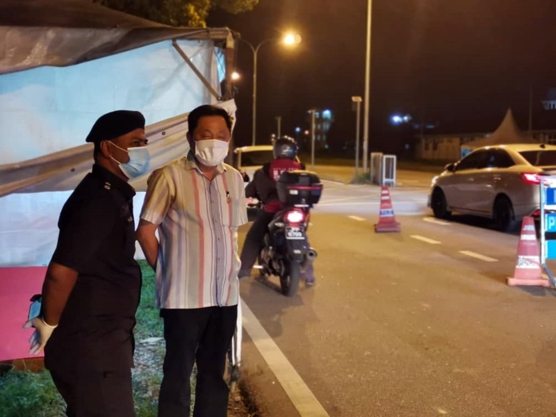 陈勇鸣（右）向驻守路障的警员了解塞车情况。