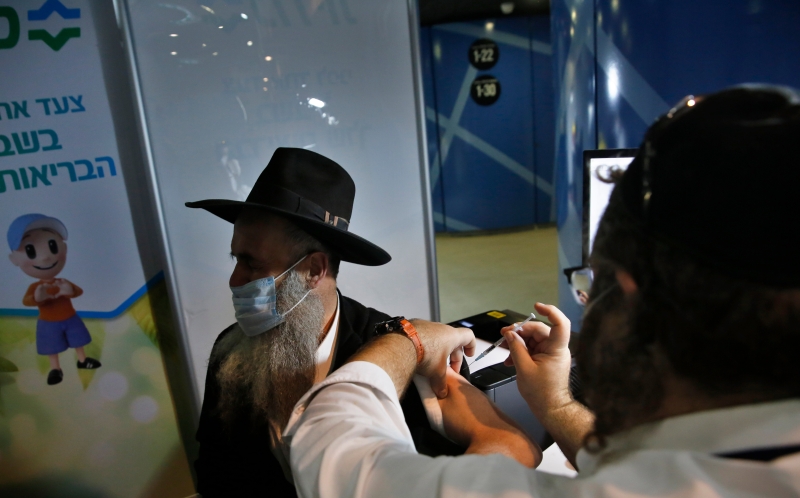 在以色列耶路撒冷的一处卫生服务站，一名男子接种冠病疫苗。 