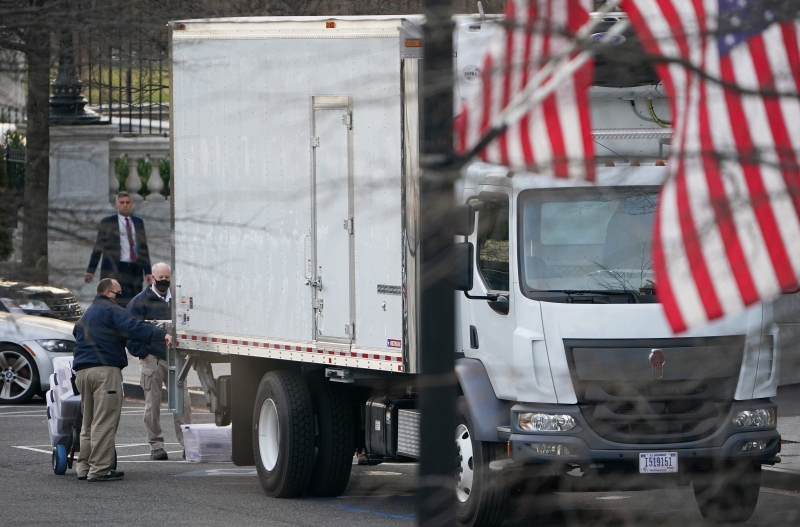 白宫人员将一箱箱物品送上一辆停泊在西行政大道的货车。（图：法新社）