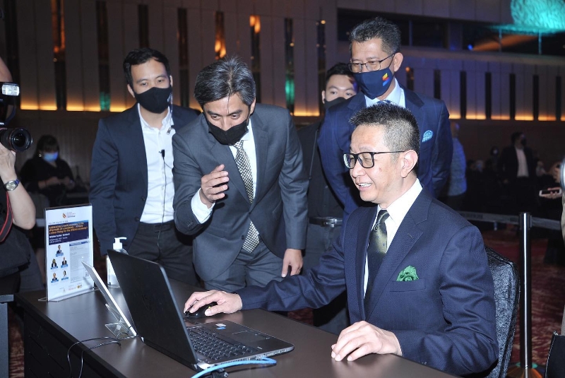 邓章钦（右一）在去年的雪兰莪国际商务峰会上，体验商务中心线上平台。