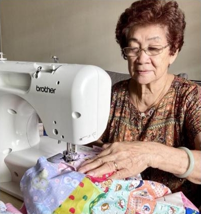 84岁的黄玉莲在病毒阻断措施学会使用缝纫机，现在每天会花上六小时缝制百衲被。（受访者提供）