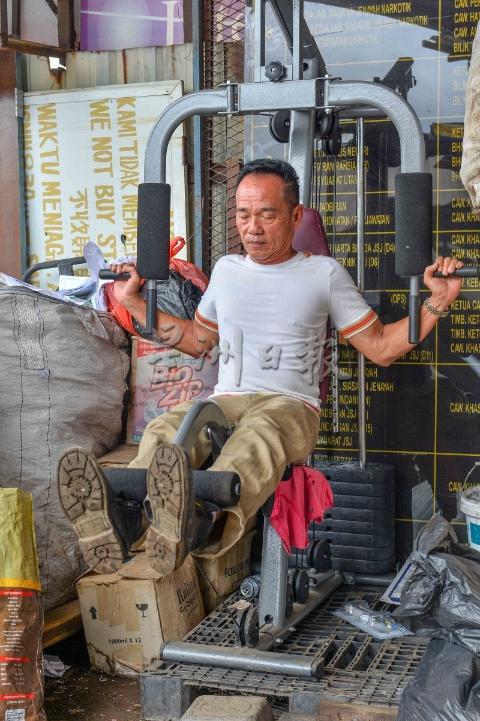 丁年福将回收到的健身器材，置放在工厂外，而他每天都会健身维持强壮体魄。