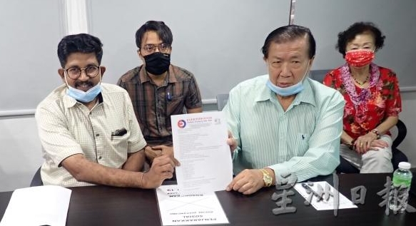 Ng Say Khoon, managing director of Everthrough Rubber Products Sdn Bhd (R2) and factory manager Shanmugam (L) showing a letter of complaint to the human resources ministry. SIN CHEW DAILY