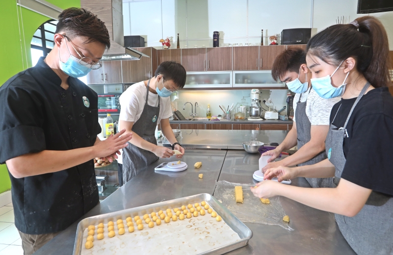 王承耀（左一）与团队在疫情期间，从教学转战生产线，网售多种糕点和面包，获得不俗反映。