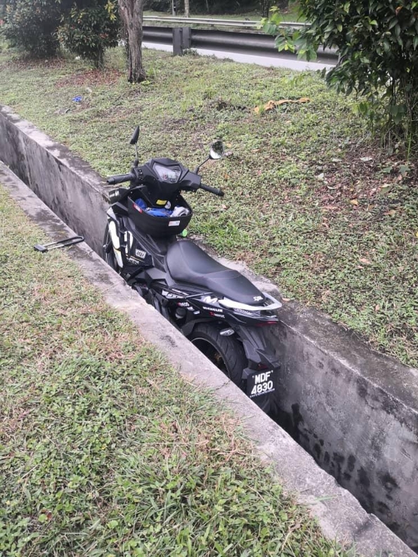2匪失手被擒，骑乘的摩托车也跌进排水沟。