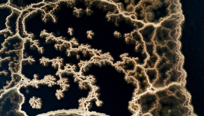 Aerial view showing patterns formed by crystallized  minerals on the surface evaporation ponds of the Dead Sea, near the southern Israeli community village of Neve Zohar. AFP