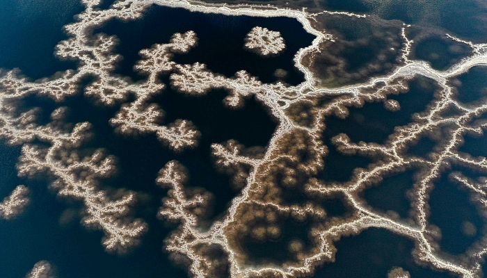 Aerial view showing patterns formed by crystallized minerals on the surface evaporation ponds of the Dead Sea, near the southern Israeli community village of Neve Zohar. AFP