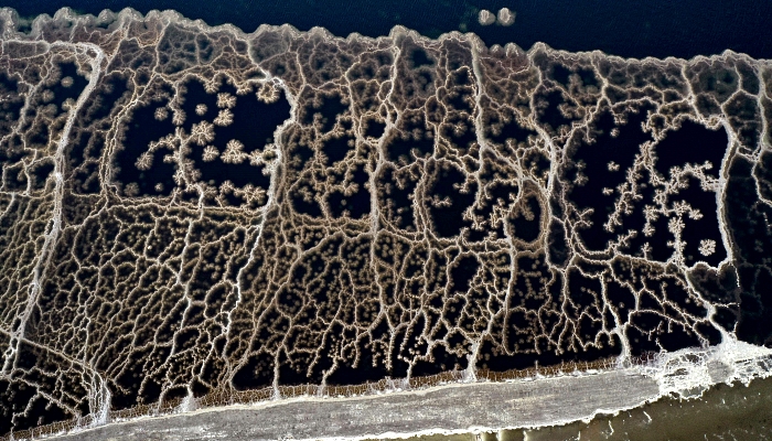 Aerial view showing patterns formed by crystallized minerals on the surface evaporation ponds of the Dead Sea, near the southern Israeli community village of Neve Zohar. AFP