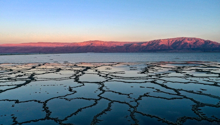 Aerial view showing patterns formed by crystallized minerals on the surface evaporation ponds of the Dead Sea, near the southern Israeli community village of Neve Zohar. AFP