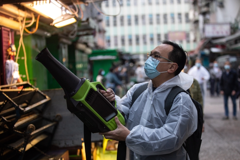一名穿着防护用具的工人在进行消毒工作。（图：欧新社）