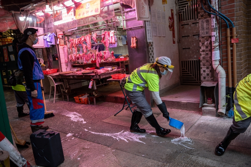 工人在市场外的人行道上以消毒剂清洗地上。（图：欧新社）