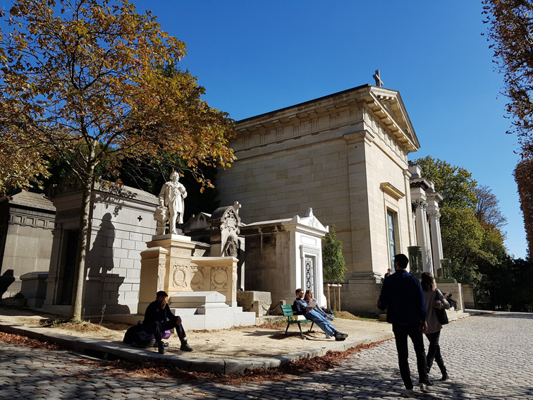 蓝天白云，访客们坐在墓地前阅读，晒太阳和约会。