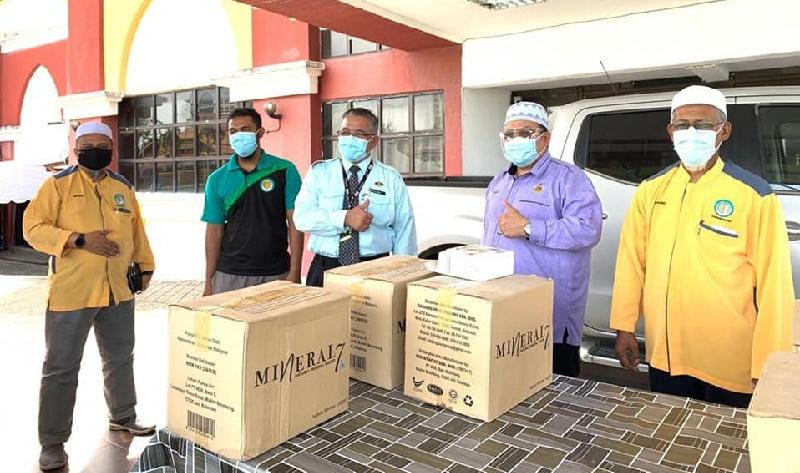 希尔米阿都拉（右二）与达鲁沙兰伊斯兰医药协会治疗师将“圣水”送至隔离中心给冠病患者使用。