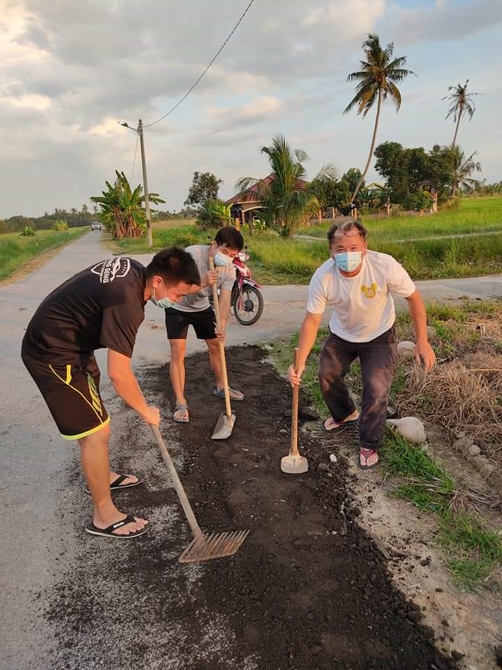 峇眼甸渔村村民在傍晚时分，参与修补家乡小路的善举。