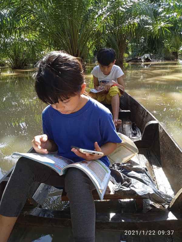 保佛甘榜拉比上周遭遇水灾，一名母亲苏芝雅娜划船载着2名孩子寻找网络信号，让他们进行线上学习。
