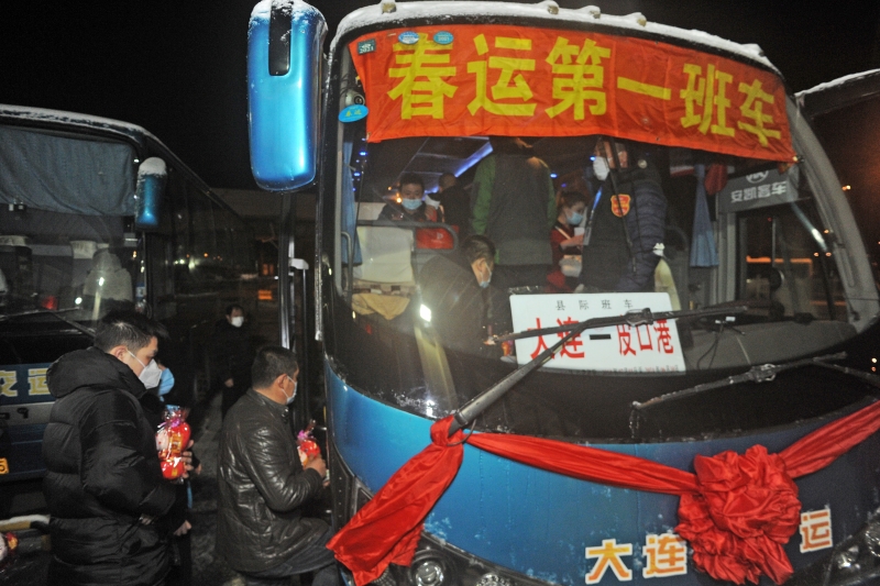 乘客在辽宁省大连交运集团汽车客运总站登上长途大巴车，乘坐春运第一班车返乡。  