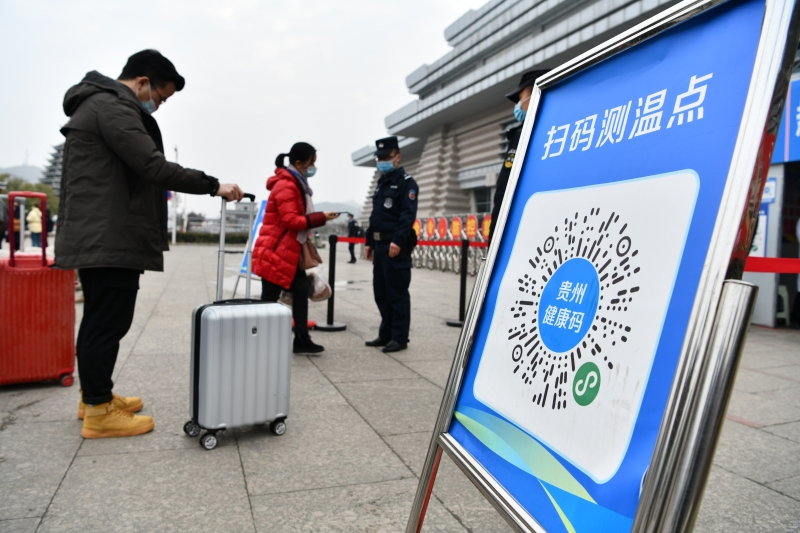 贵州省凯里南高铁站铁路派出所的警员引导乘客用手机扫描健康码进站乘车。