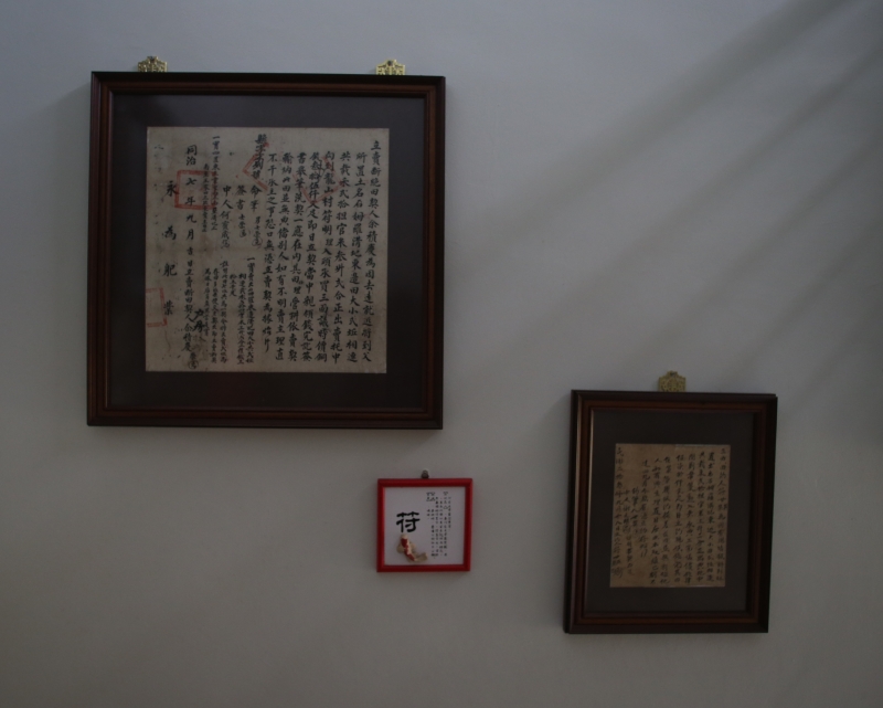 符气洲把古旧的地契框起来，挂在楼梯间的墙面展示。