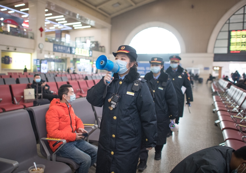 汉口火车站的工作人员在候车厅宣讲乘车防疫事项。