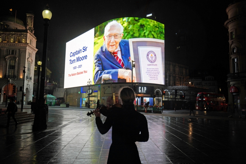 伦敦市中心的比卡迪里广场巨大萤幕播放穆尔的照片，表示“全国向您致敬”。（美联社照片）