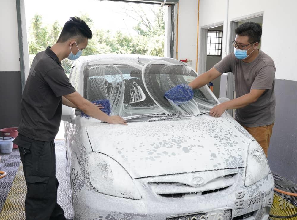 陈家俊（左）和搭档李家俊合力把车子清洗乾净。