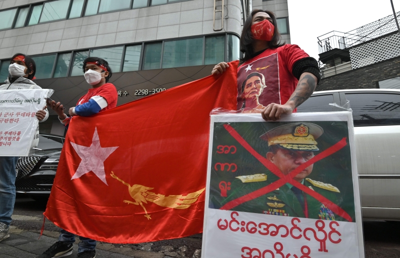 旅居韩国的缅甸示威者手持被画上大红叉的军政府领导人敏昂莱肖像，在缅甸驻韩国大使馆外示威抗议。