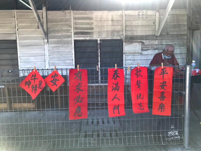 冯东将挥春作品张挂在行人道的围篱上，也为热水湖大街增添一份春意。