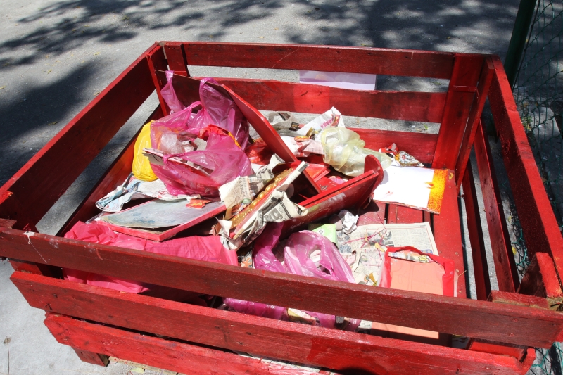 即使是要丢弃了，一些民众仍把祭神用品包好再投入玫瑰园的“祭神物品回收处”。