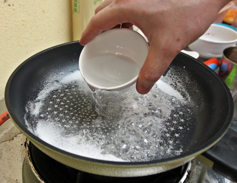 干锅里以2:1的比例，倒入糖及清水煮。