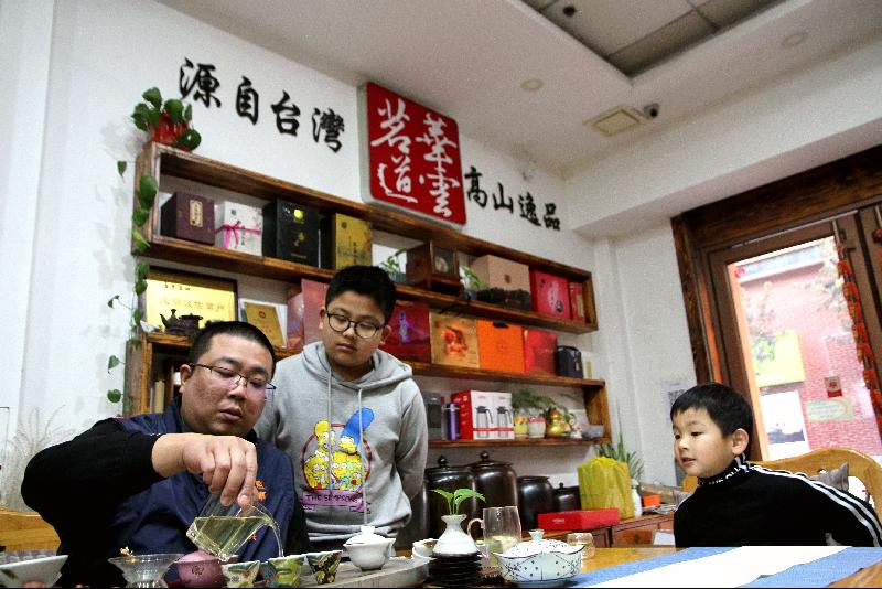 台湾茶商陈宗棋今年决定留在济南过年，不回台湾与亲人团聚。图为陈宗棋正在教儿子们泡茶。（中新社照片）