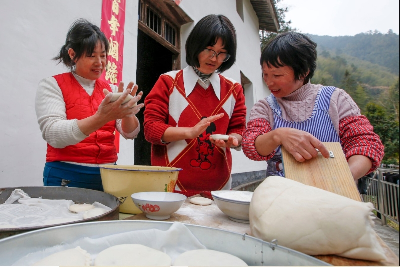 图为徐晓婵（中）在村民家中做米粿。（新华社照片）